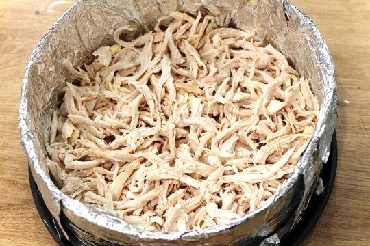 выкладываем слой разделанной куриной грудки, перемешанной с маринованным луком